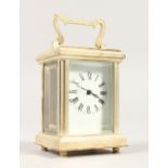 A MINIATURE CARRIAGE CLOCK, with silver plated case and white enamel dial. 8cms high.