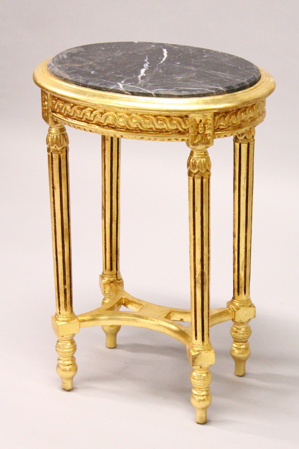 A FRENCH STYLE GILTWOOD OVAL TABLE, inset with a black marble top. 50cms wide x 72cms high.