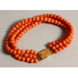 A LONG CORAL NECKLACE with gold clasp.