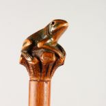 A FOLK ART WALKING STICK with carved frog handle.