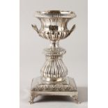 A CONTINENTAL SILVER TWO HANDLED URN ON STAND.15cms high.