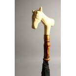 AN IVORINE HANDLED PARASOL, carved with a horse handle. 94cms long.