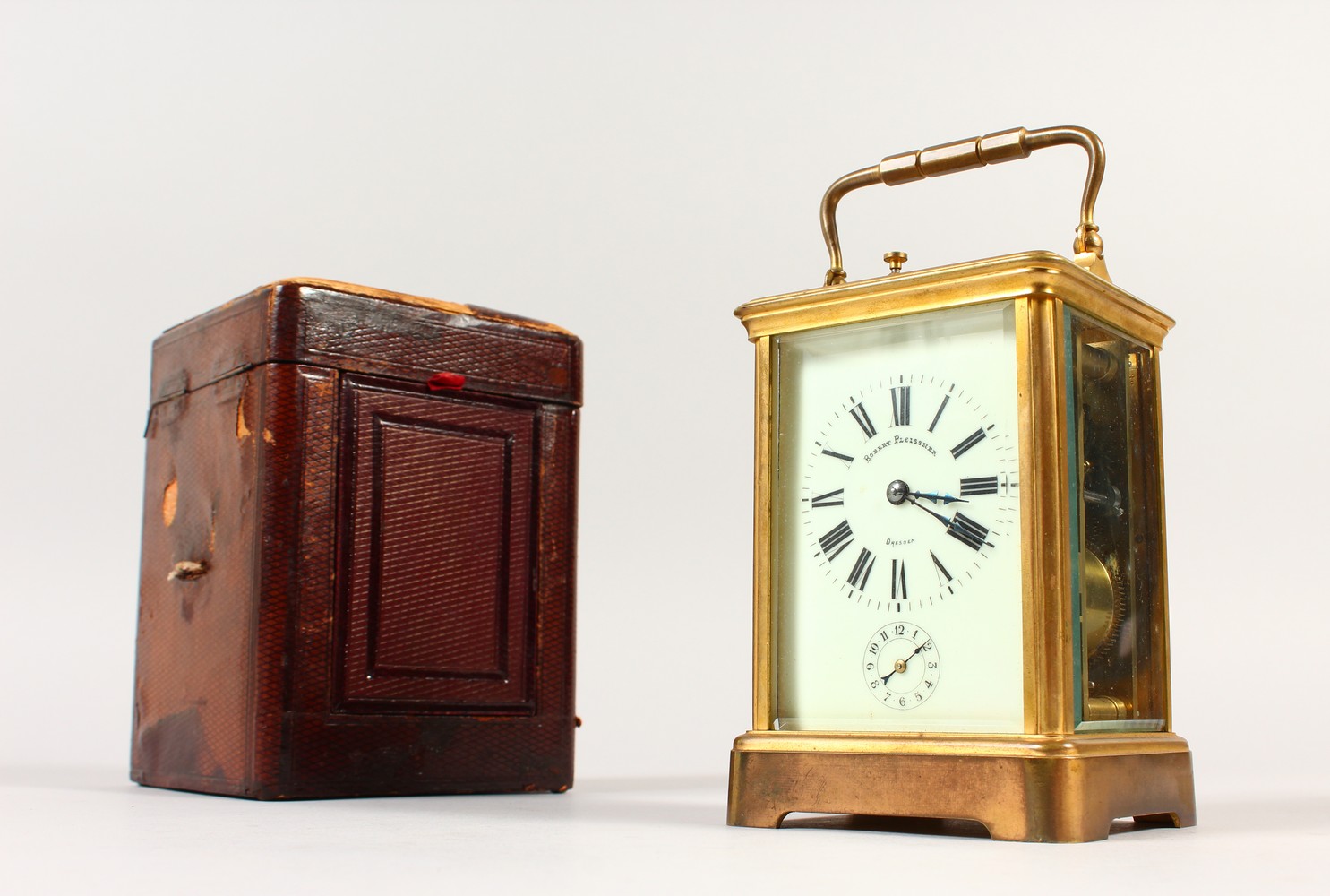 A FRENCH BRASS CARRIAGE CLOCK, with repeat and alarm, striking on a gong, in a leather case. 14cms