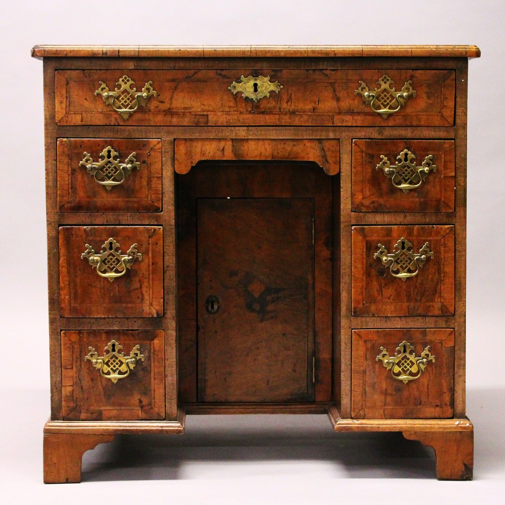 AN 18TH CENTURY WALNUT KNEEHOLE DESK, with quarter veneered top, one frieze drawer, a central