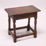 AN 18TH CENTURY OAK JOINT STOOL, with moulded top, carved frieze on turned legs united by