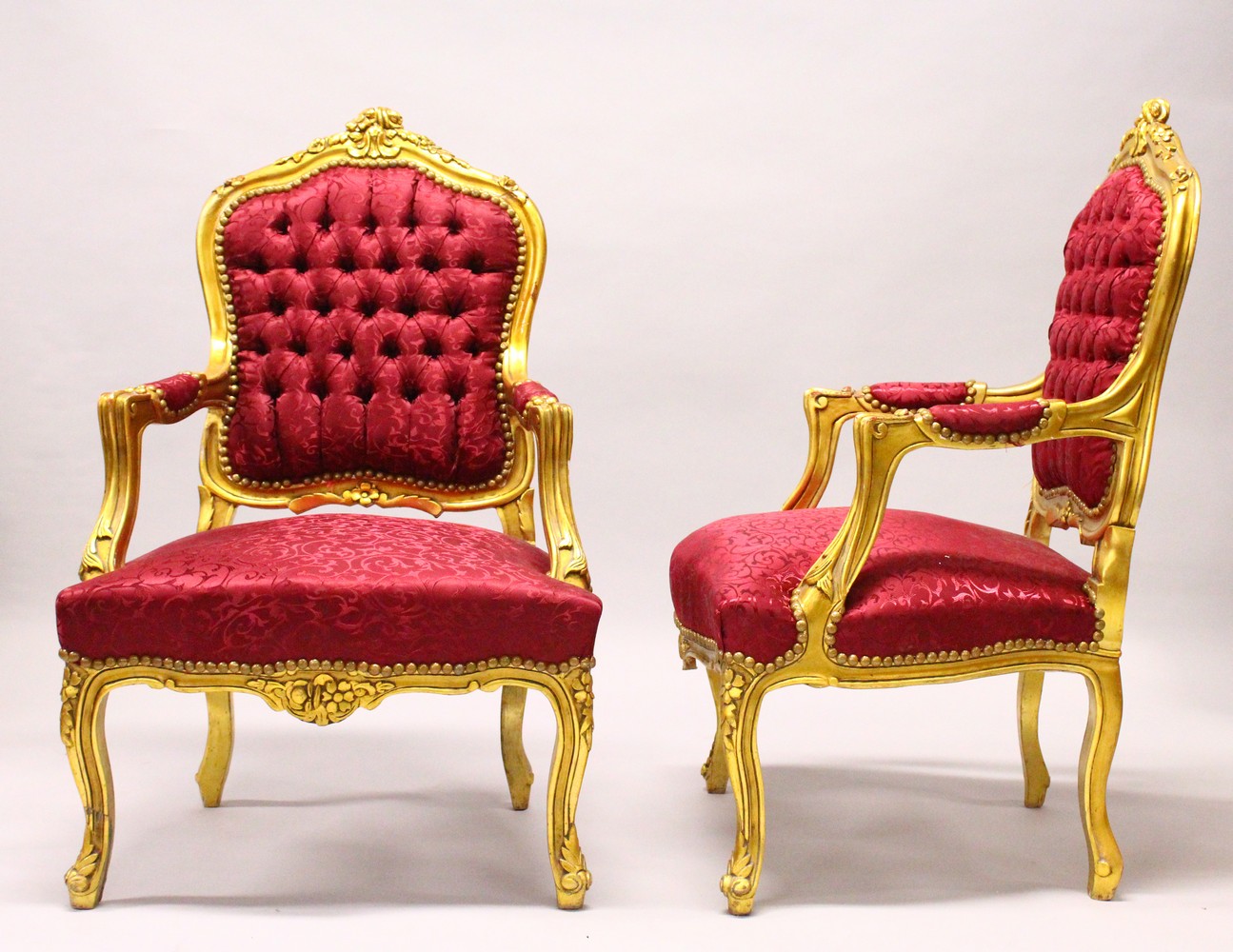 A PAIR OF FRENCH STYLE GILTWOOD ARMCHAIRS, with classical style maroon upholstery.