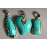 THREE SILVER AND TURQUOISE PENDANTS.