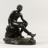 AFTER THE ANTIQUE A BRONZE OF HERMES, sitting on a rock. 19cms high.