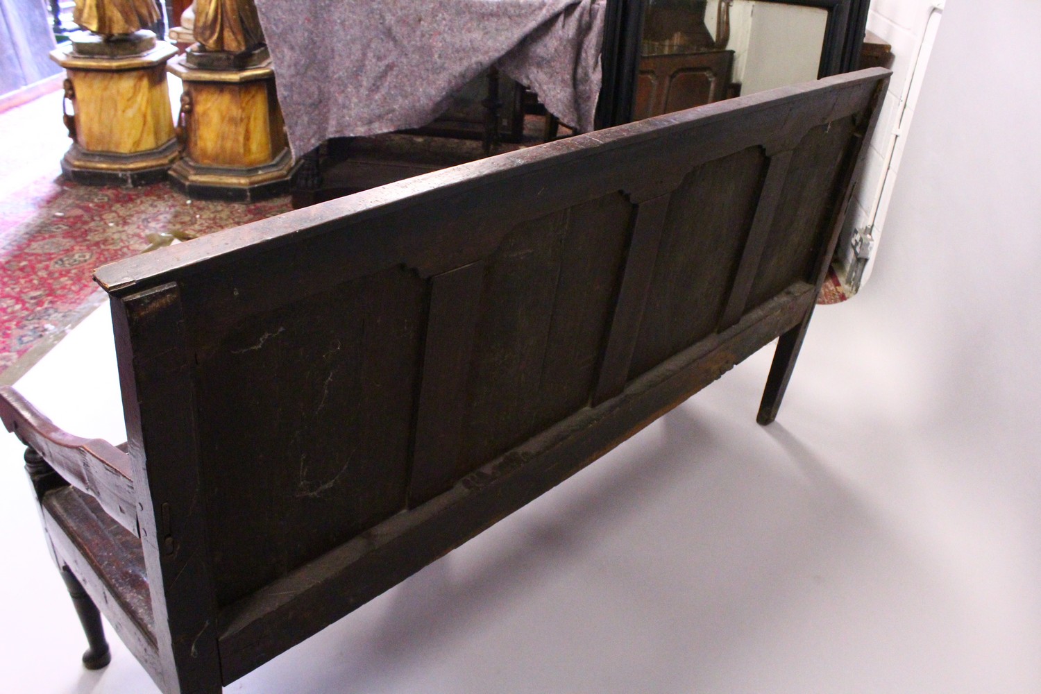 AN 18TH CENTURY OAK SETTLE, with a four panel back, curving arms, solid seat, on cabriole front - Image 8 of 13