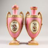 A PAIR OF ENGLISH TWO-HANDLED VASES, pink ground edged in gilt and painted with reverse panels of