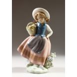 A LLADRO PORCELAIN FIGURE, young girl carrying a basket of flowers, No. 522. 15cms high.