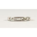 A 14CT WHITE GOLD CHANNEL SET DIAMOND HALF ETERNITY RING.