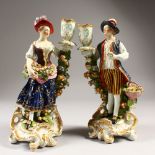 A PAIR OF DERBY CANDLESTICK FIGURES, gallant and lady in rich garb, each with a candlestick