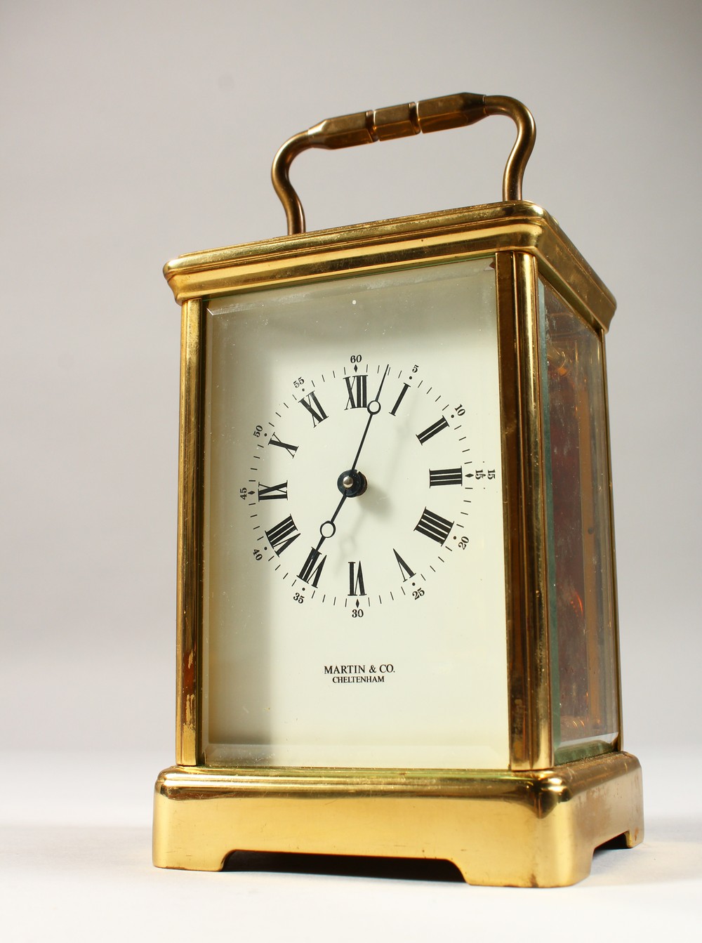 MARTIN & CO., CHELTENHAM, an English brass carriage timepiece, white dial with black Roman numerals.