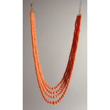 A LONG CORAL NECKLACE with gold clasp.