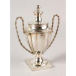 A PLAIN TWO HANDLED CONTINENTAL SILVER CHALLENGE CUP with rope twist handle. 18cms high. Weight