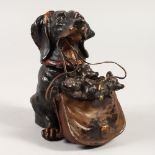 A COLD PAINTED BRONZE INKWELL, modelled as a dog holding a bag of puppies in it's mouth. 12cms
