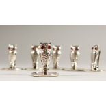 A SET OF SIX SILVER OWL MENU HOLDERS.