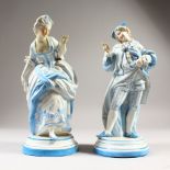 A PAIR OF CONTINENTAL LIGHT BLUE AND WHITE PORCELAIN FIGURES OF A GALLANT AND LADY. 26cms high.