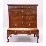 AN EARLY 18TH CENTURY WALNUT CHEST ON STAND, with a herringbone inlaid top, four graduated long