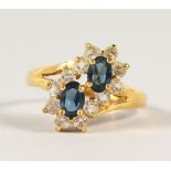 AN 18CT GOLD AND SAPPHIRE CROSSOVER RING.