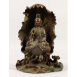 A CHINESE BRONZE FIGURE OF GUANYIN, seated on a lotus pod. 28cms high.