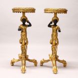 A PAIR OF DECORATIVE BLACKAMOOR STANDS, on tripod bases. 96cms high.