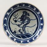 A CHINESE CIRCULAR DISH, painted in blue and white with a dragon. 28.5cms diameter.