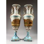 A PAIR OF SEVRES STYLE URN SHAPED VASES, with sphynx handles, decorated with a street scene. 19ins