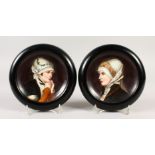 A SMALL PAIR OF FRAMED CONTINENTAL PORCELAIN PLAQUES of young ladies. 14cms diameter.