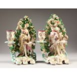 A GOOD PAIR OF DERBY CANDLESTICK GROUPS, classical lady with a cupid standing before a bocage, on