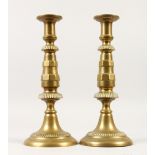 A TALL PAIR OF EARLY BRASS CANDLESTICKS, on circular bases. 31cms high.