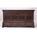 A 19TH CENTURY OAK COFFER, with twin plank top, carved front and apron, the shaped ends with wrought