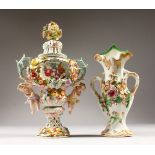 A CONTINENTAL FLOWER ENCRUSTED TWO-HANDLED URN AND COVER, encrusted with flowers and cupids, and