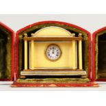 A GOOD SMALL SILVER GILT AND YELLOW ENAMEL TRAVELLING CLOCK, with dome top and columns to each side,