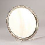 A PLAIN CIRCULAR SALVER, with gadrooned edge on three feet. 20cms diameter. London 1938. Weight