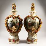 A PAIR OF MEISSEN STYLE VASES, COVERS AND STANDS, with floral and fruit encrusted decoration.
