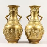 A LARGE PAIR OF CHINESE POLISHED BRASS TWIN-HANDLED VASES, decorated with figures. 39cms high.
