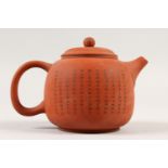 A CHINESE YIXING TEAPOT, decorated with calligraphy. 12cms high.