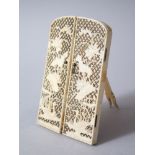 A 19TH CENTURY JAPANESE CARVED IVORY FOLDING FRAME, the latched doors carved and pierced with scenes