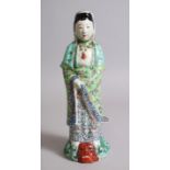 A CHINESE PORCELAIN FAMILE VERTE FIGURE OF GUANYING, dressed in traditional attire and stood upon