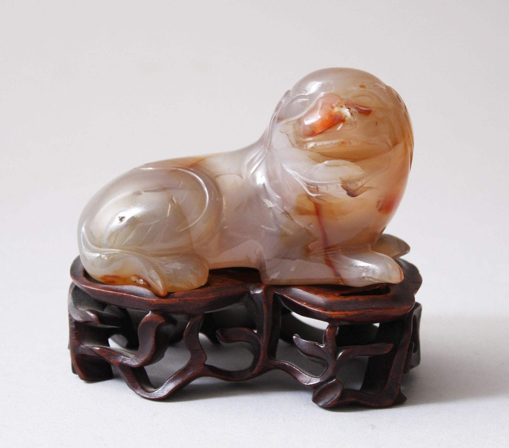 A 19TH CENTURY CHINESE AGATE CARVED FIGURE OF A DOG & HARDWOOD STAND, the agate dog measures 5cm