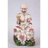 A GOOD JAPANESE KUTANI PORCELAIN MODEL OF AN ARHAT, the arhat with a low expression upon his face,