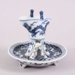 A CHINESE MING STYLE PORCELAIN LIBATION CUP & BASE, the tripod formed cup decorated with scenes of a