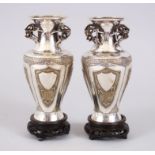 A PAIR OF CHINESE SILVER & SILVER GILT VASES ON HARDWOOD STANDS, the vases each with panels