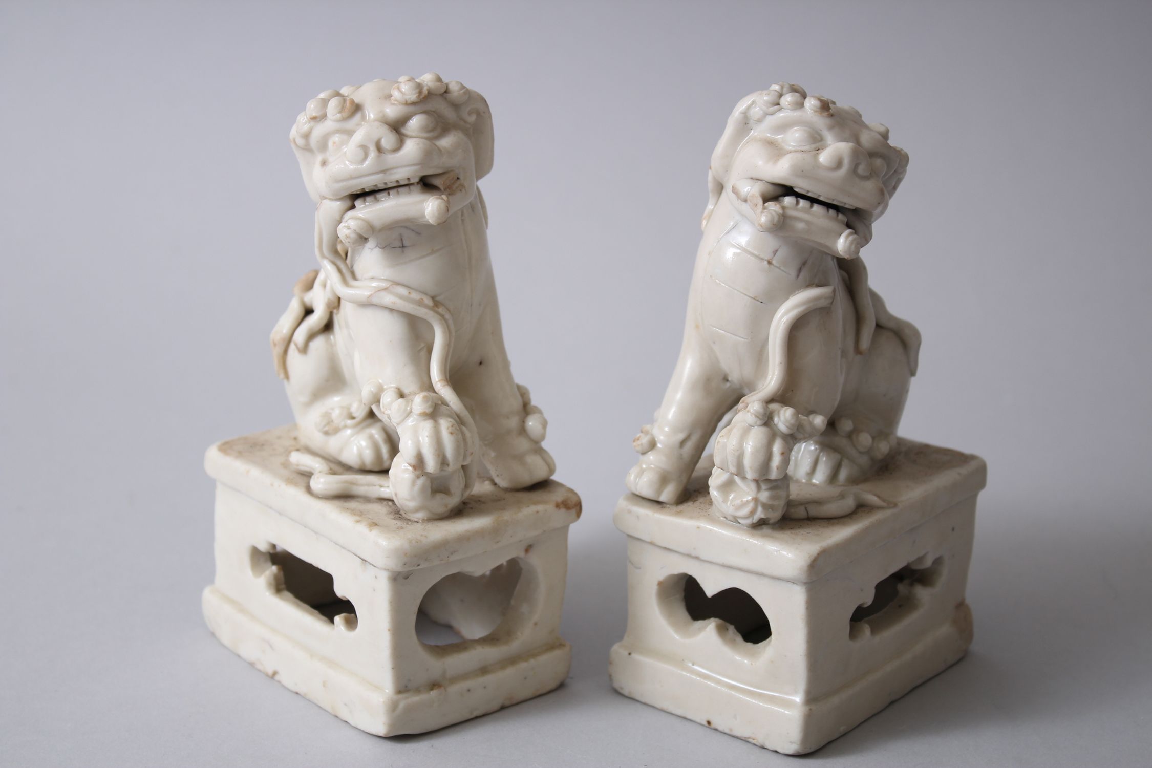 PAIR OF 19TH CENTURY CHINESE CHINE DE BLANC / DEHUA LION DOG FIGURES, both seated upon pierced - Image 2 of 4