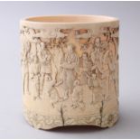 A GOOD JAPANESE MEIJI PERIOD CARVED IVORY TUSK SECTION BRUSH POT, carved in relief with a figurative