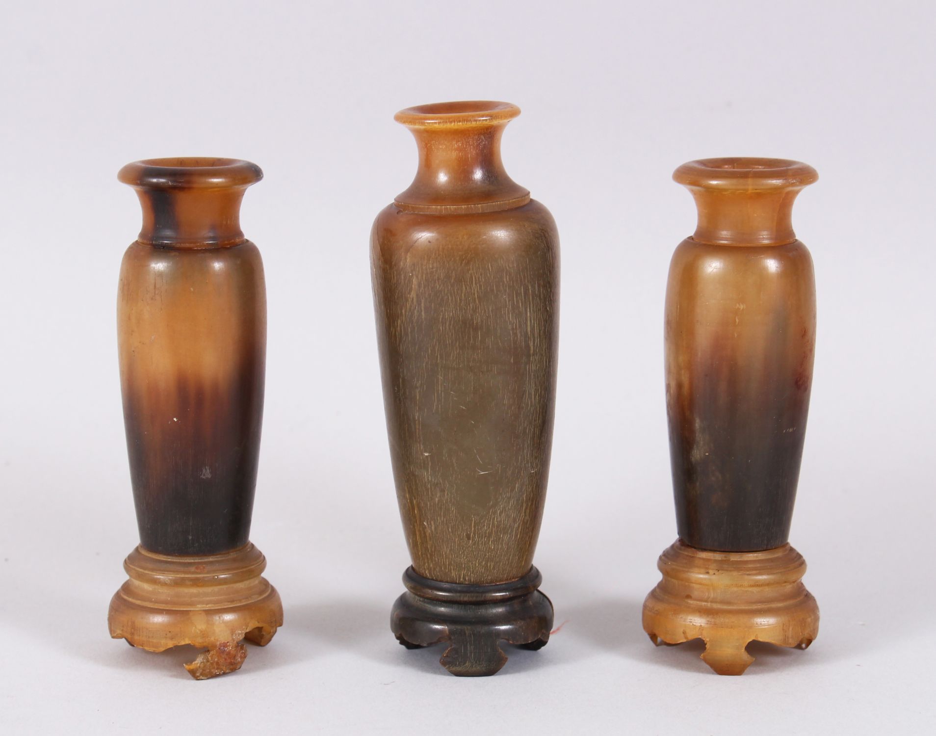A GOOD GARNITURE OF THREE RHINO HORN TURNED VASES ON STANDS, 12cm x 11cm high. Weight 234gms.