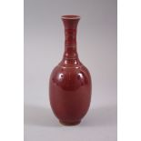 AN EARLY 20TH CENTURY CHINESE SANG DE BOEUF PORCELAIN VASE, in copper red, 20.4cm high x 8cm wide.