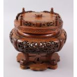 A CHINESE 19TH CENTURY CARVED AND PIERCED HARD WOOD ROTATING STAND, the sides carved and pierced